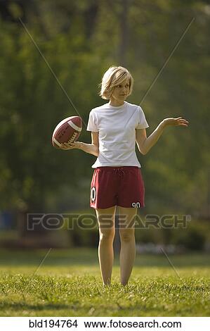 Uncertain woman holding football View Large Photo Image Picture - Uncertain woman holding football. Fotosearch