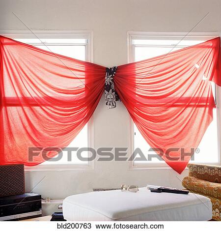 Stock Image - Unusual red curtains in living room. Fotosearch