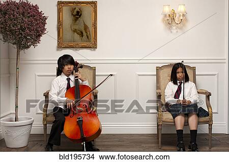Picture - Vietnamese children with musical instruments sitting on elegant chairs. Fotosearch
