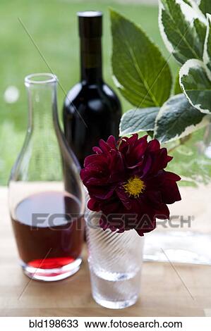 Stock Image - Wine in carafe and flower in vase. Fotosearch
