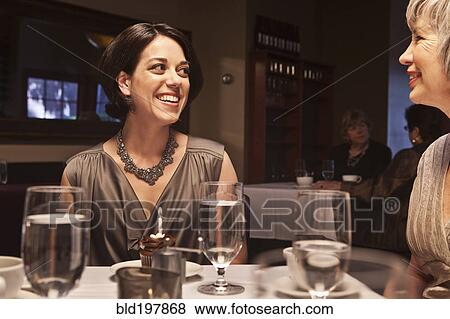Woman about to blow out birthday cupcake in restaurant View Large Photo Image Stock Photo - Woman about to blow out birthday cupcake in restaurant. Fotosearch