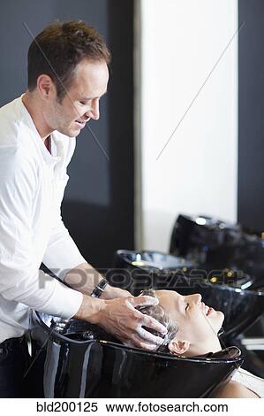 Stock Photography - Woman having hair washed in salon. Fotosearch