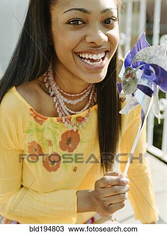 Stock Image - Woman holding pinwheel. Fotosearch