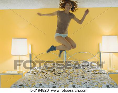 Woman jumping on bed View Large Photo Image Stock Image - Woman jumping on bed. Fotosearch