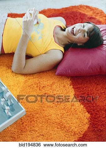 Woman laying on pillow on floor View Large Photo Image Stock Photograph - Woman laying on pillow on floor. Fotosearch