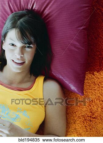 Stock Photography - Woman laying on pillow on floor. Fotosearch