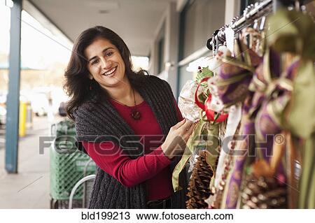 Stock Image - Woman looking at merchandise for sale. Fotosearch