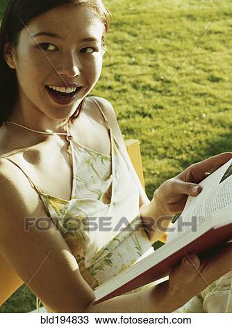 Woman reading book in chair View Large Photo Image Stock Image - Woman reading book in chair. Fotosearch