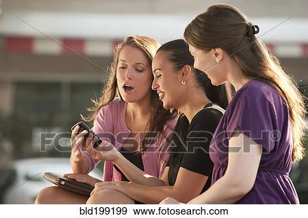 Woman showing cell phone to friends View Large Photo Image Stock Photo - Woman showing cell phone to friends. Fotosearch