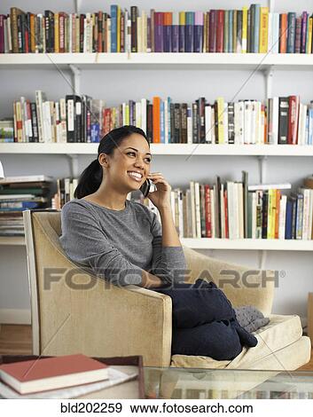 Woman sitting in chair talking on cell phone View Large Photo Image Stock Photo - Woman sitting in chair talking on cell phone. Fotosearch