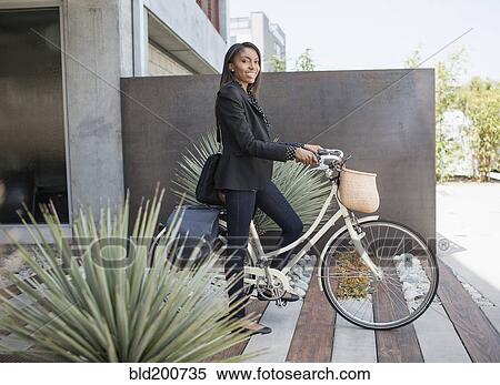 Woman standing with bicycle View Large Photo Image Stock Photography - Woman standing with bicycle. Fotosearch