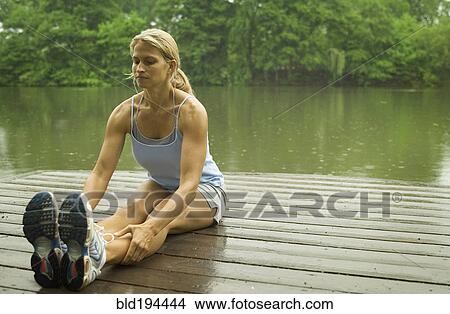 Picture - Woman stretching on pier. Fotosearch