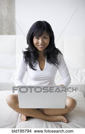 Woman using laptop in living room View Large Photo Image Picture - Woman using laptop in living room. Fotosearch
