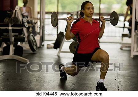 Stock Photography - Woman weight lifting in health club. Fotosearch