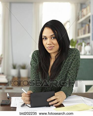 Stock Photography - Woman writing in checkbook. Fotosearch