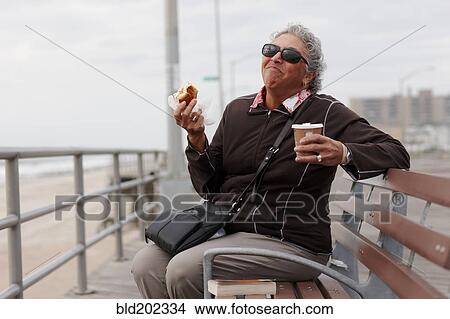 Women eating pastry and drinking coffee on boardwalk View Large Photo Image Picture - Women eating pastry and drinking coffee on boardwalk. Fotosearch