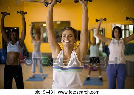 Women lifting weights in health club View Large Photo Image Stock Image - Women lifting weights in health club. Fotosearch