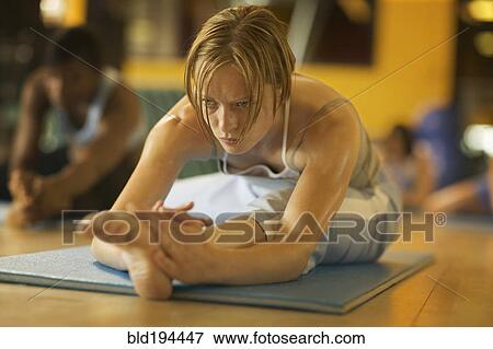 Stock Photo - Women practicing yoga in health club. Fotosearch