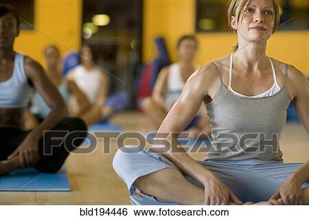 Stock Photograph - Women practicing yoga in health club. Fotosearch