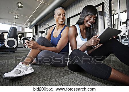 Stock Photography - Women using digital tablet in health club. Fotosearch