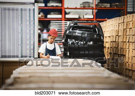 Worker examining product in manufacturing plant View Large Photo Image Stock Image - Worker examining product in manufacturing plant. Fotosearch
