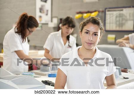 Stock Image - Worker smiling in manufacturing plant. Fotosearch