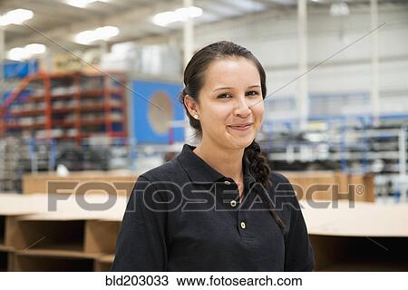 Worker smiling in manufacturing plant View Large Photo Image Stock Image - Worker smiling in manufacturing plant. Fotosearch