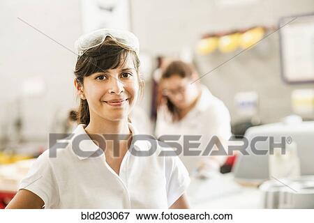 Worker smiling in manufacturing plant View Large Photo Image Stock Photo - Worker smiling in manufacturing plant. Fotosearch