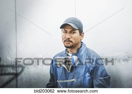 Stock Image - Worker standing in manufacturing plant. Fotosearch