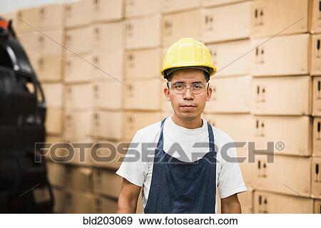 Stock Photo - Worker standing in manufacturing plant. Fotosearch