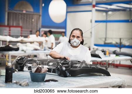 Stock Photography - Worker wearing face mask in manufacturing plant. Fotosearch