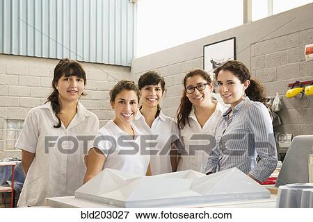 Stock Photo - Workers smiling in manufacturing plant. Fotosearch