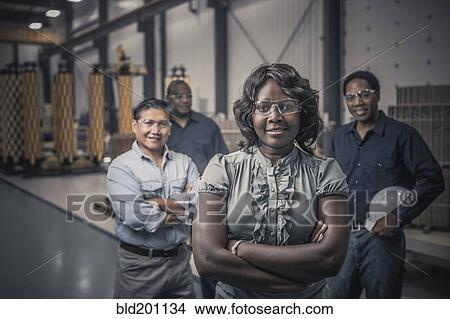 Picture - Workers standing together in factory. Fotosearch