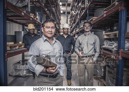Picture - Workers standing together in factory. Fotosearch