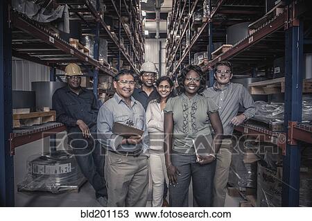 Stock Image - Workers standing together in factory. Fotosearch