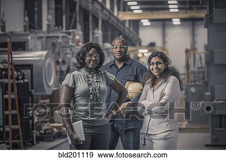 Stock Photo - Workers standing together in factory. Fotosearch