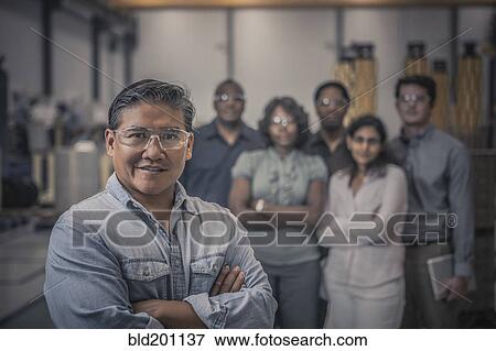 Stock Photo - Workers standing together in factory. Fotosearch