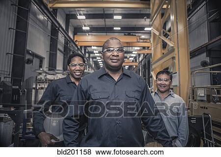 Stock Photo - Workers standing together in factory. Fotosearch