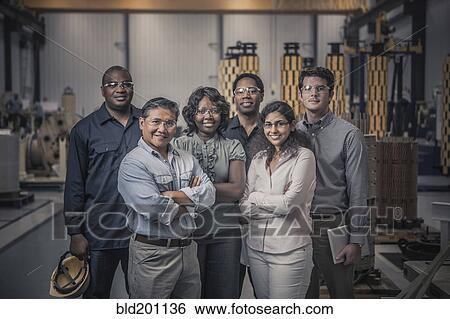 Stock Photograph - Workers standing together in factory. Fotosearch