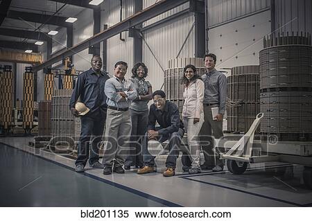 Stock Photography - Workers standing together in factory. Fotosearch