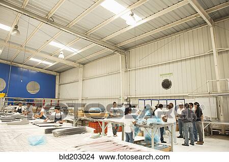 Picture - Workers talking in manufacturing plant. Fotosearch