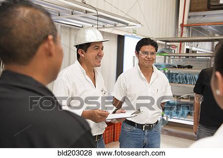 Workers talking in manufacturing plant View Large Photo Image Stock Photo - Workers talking in manufacturing plant. Fotosearch