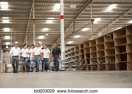 Stock Photo - Workers talking in manufacturing plant. Fotosearch