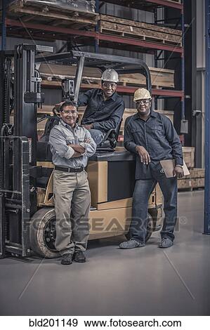 Stock Photo - Workers with forklift in factory. Fotosearch