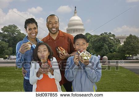 Stock Photography - African American family eating hot dogs on vacation. Fotosearch