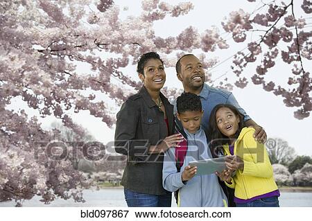 Stock Photo - African American family using digital tablet on vacation. Fotosearch