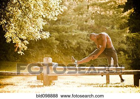 Stock Photo - African American man stretching before exercise. Fotosearch