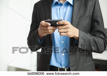 Black businessman text messaging on cell phone View Large Photo Image Stock Photograph - Black businessman text messaging on cell phone. Fotosearch