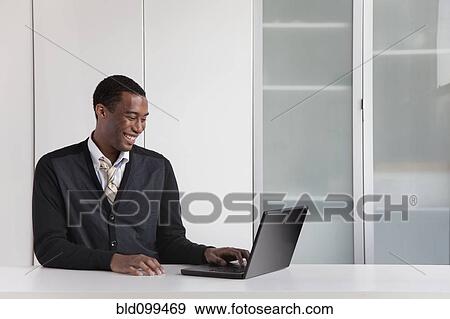Black businessman typing on laptop View Large Photo Image Stock Photo - Black businessman typing on laptop. Fotosearch