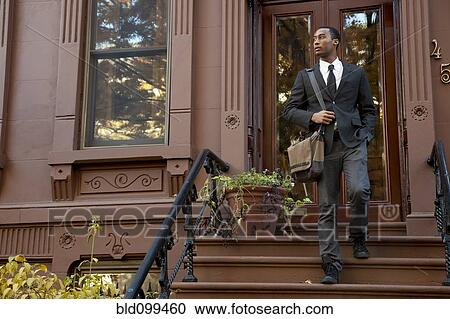 Black businessman walking down front stoop steps View Large Photo Image Stock Image - Black businessman walking down front stoop steps. Fotosearch